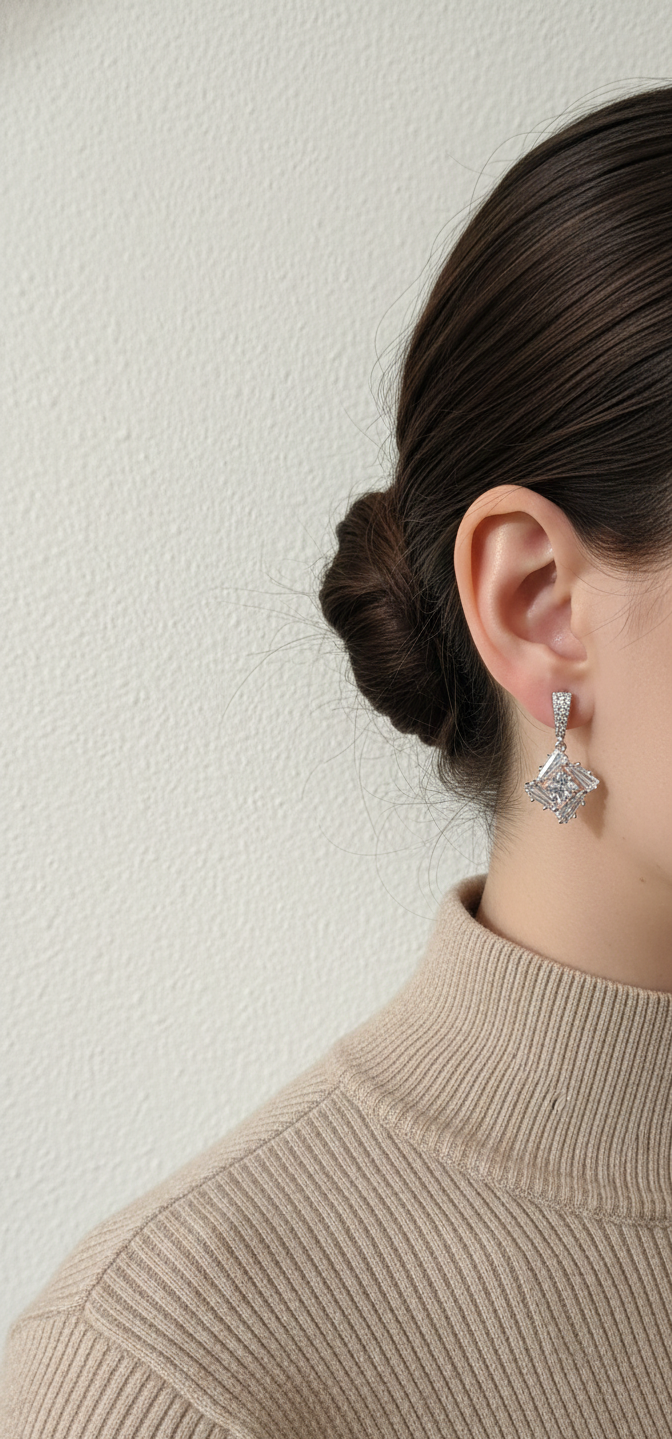 Woman wearing a silver earring against a neutral background