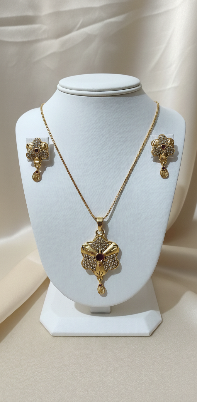 Gold necklace and earrings on a white mannequin bust with a neutral background