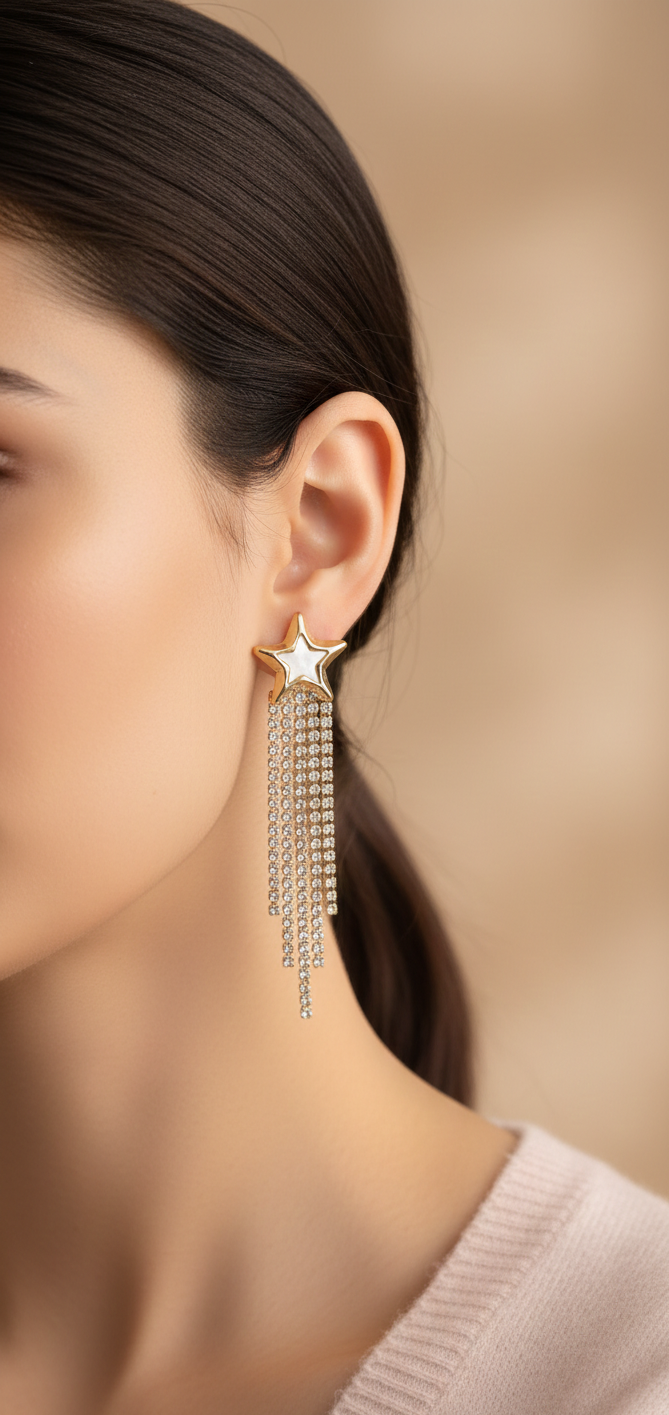 Close-up of a woman wearing a star-shaped earring with tassels against a beige background