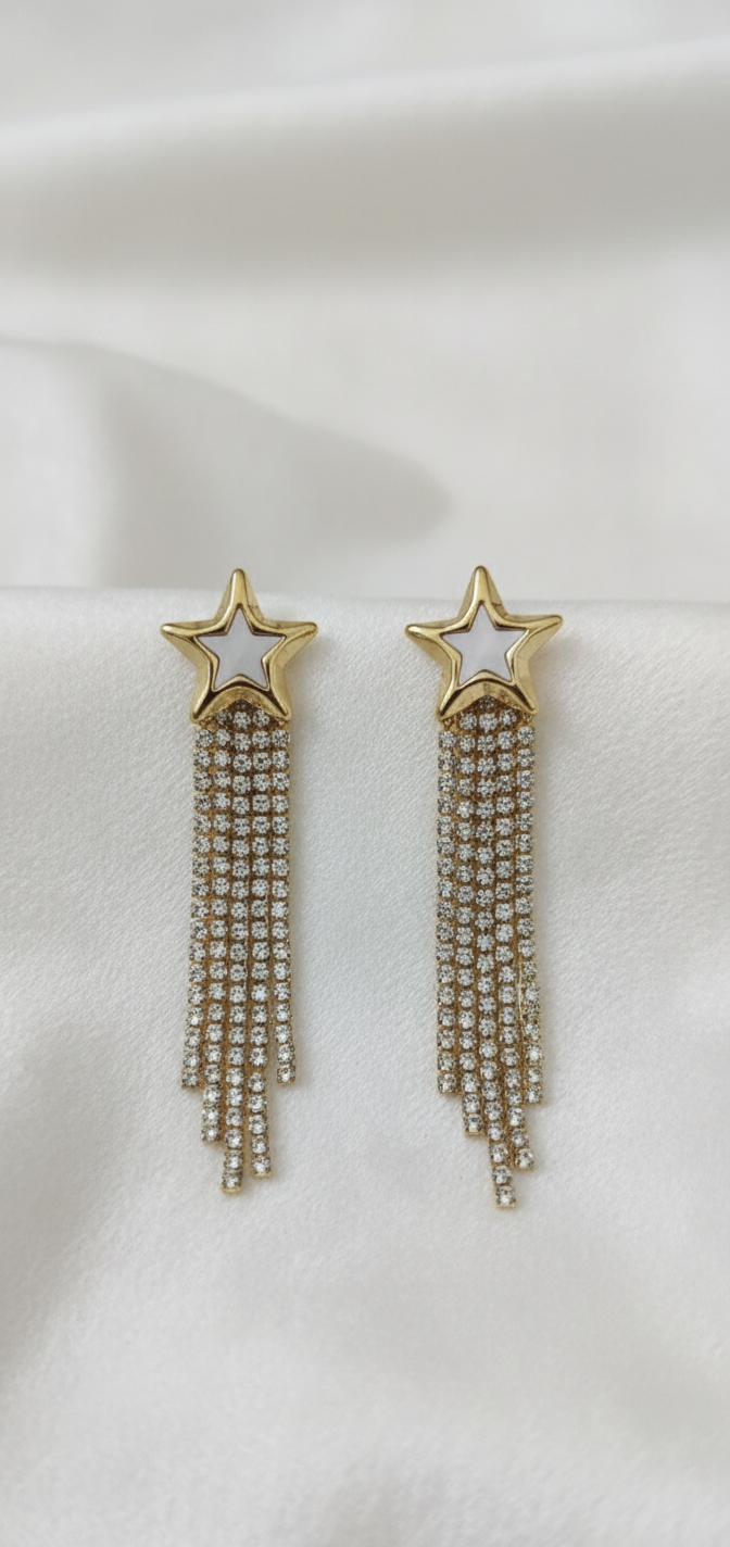 Pair of star-shaped earrings with tassel details on a white background