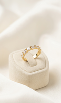 Gold ring with diamonds on a white cushion