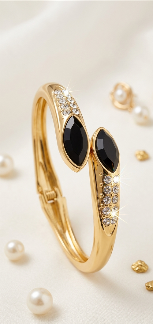 Gold bracelet with black stones and pearl beads on a white background