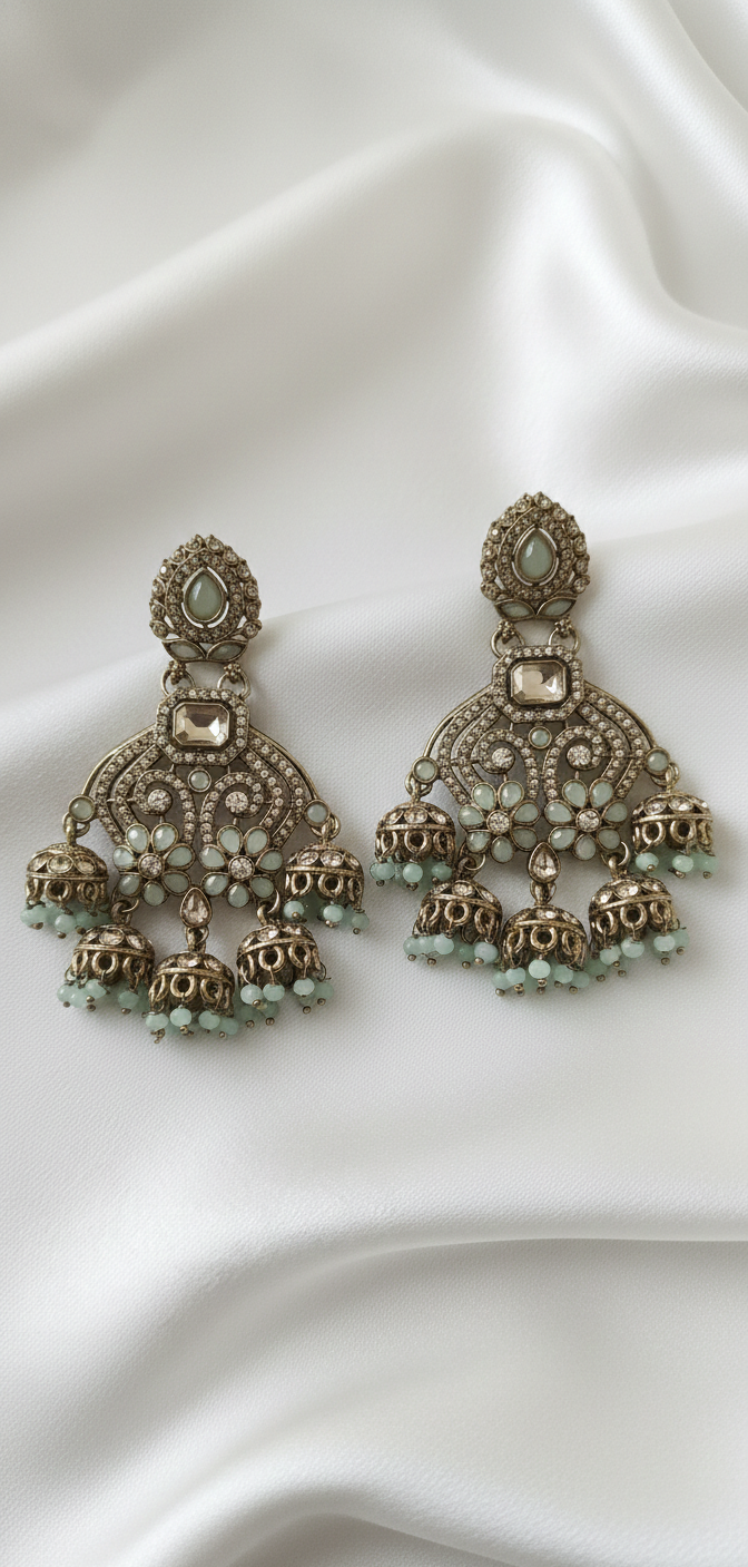 Ornate earrings with gemstones on a satin background