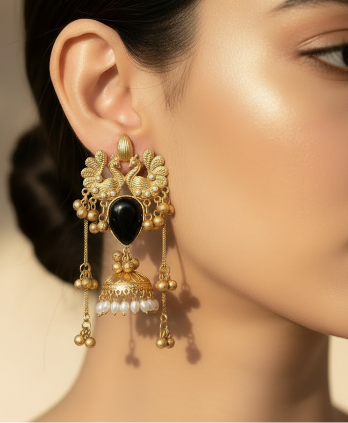 Pair of gold earrings with black stones on a white background