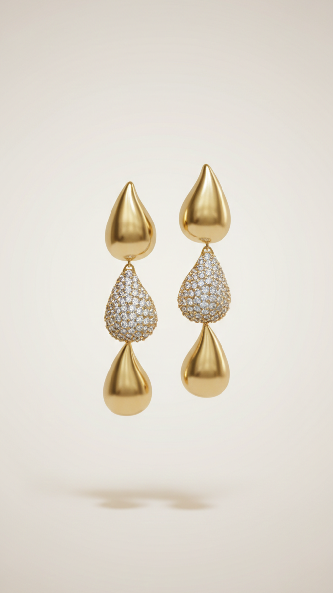 Gold earrings with teardrop-shaped designs on a beige background