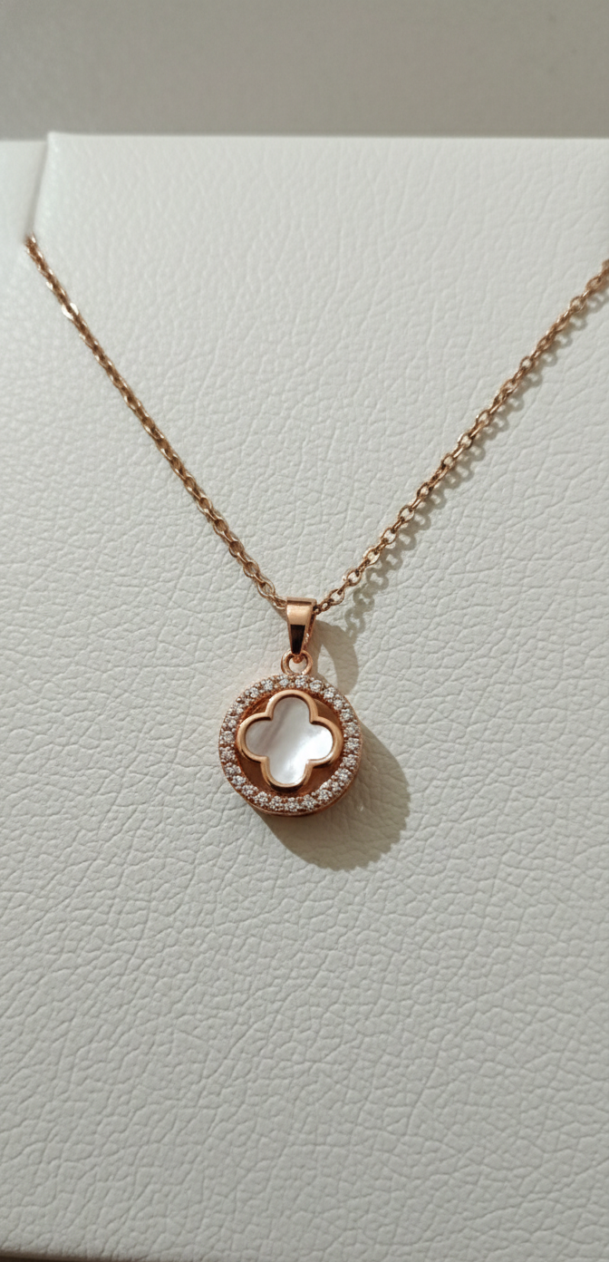 Rose gold necklace with a heart-shaped pendant on a light gray background